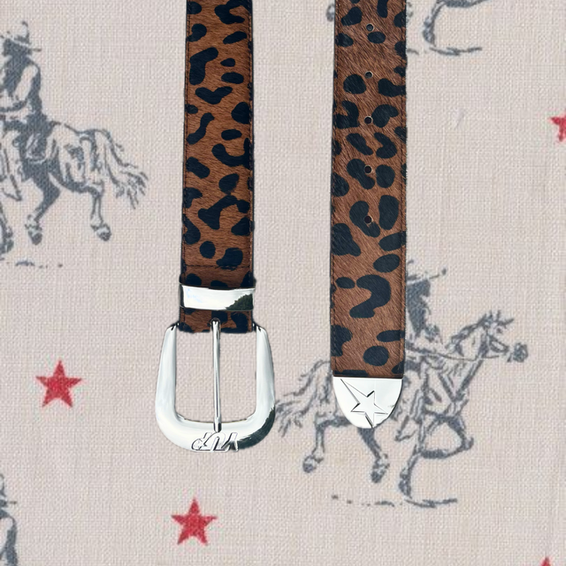 Leopard print belt with silver buckle on a patterned background