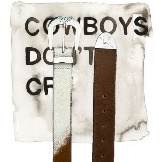 A cowhide printed belt with a silver buckle, displayed against a marble background with text.