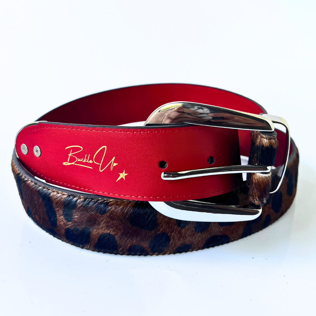 Red leather belt with a leopard strap and silver buckle on a white background