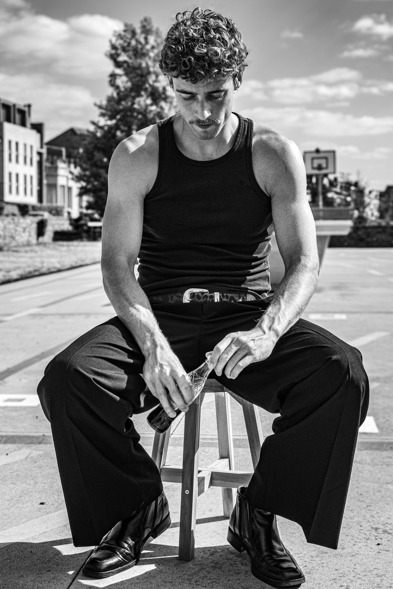 YUP belt styled with a black tank top and dark trousers outdoors